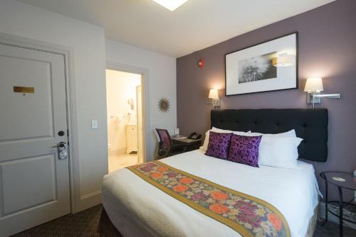 a hotel room with a bed with purple walls at Camas Boutique Hotel in Camas
