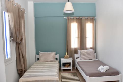 two beds in a room with two windows at Ammos Apartments in Ierápetra