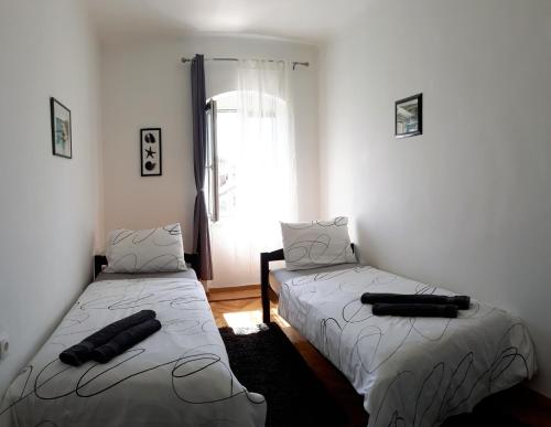 two beds in a room with a window at Centar Palace Apartment in Split