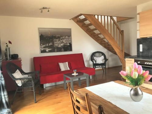 ein Wohnzimmer mit einem roten Sofa und einem Tisch in der Unterkunft Fe-Wo im Dänemarkweg in Niendorf