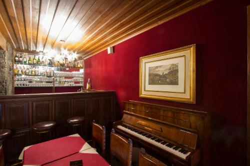 a room with a piano and a bar at Vitória Palace Hotel in Lavras