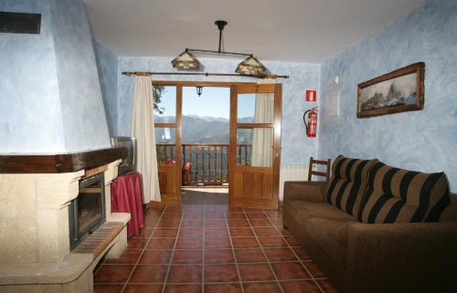 a living room with a couch and a fireplace at Viviendas Rurales Peña Sagra in Cahecho