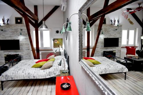 - 2 lits dans une chambre avec un miroir dans l'établissement In the Attic Apartments, à Szczecin