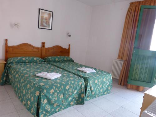 1 dormitorio con 1 cama con colcha verde en Hotel German, en Vilaflor