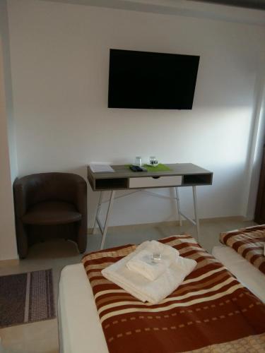 a room with a bed and a desk with a television at Guest House Harmony in Veliko Tŭrnovo