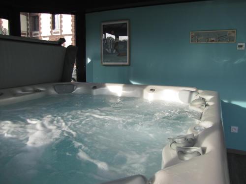 bañera llena de agua en una habitación en Villa Argonne en Ouville-la-Rivière