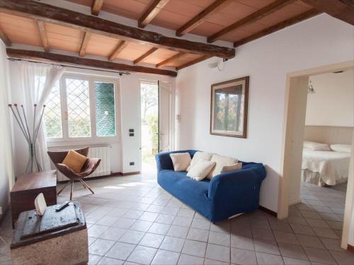 a living room with a blue couch and a bed at Villino Michela in Marina di Pietrasanta