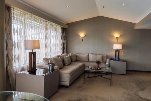 a living room with a couch and a table at Waipuna Hotel & Conference Centre in Auckland