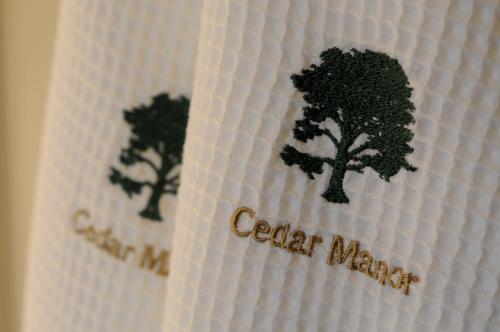 a white towel with trees on it with the words cedar wax at Cedar Manor in Windermere