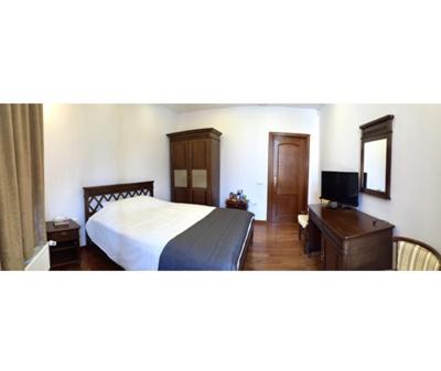 a bedroom with a bed and a desk with a television at Casa Coquette Buzau in Buzău