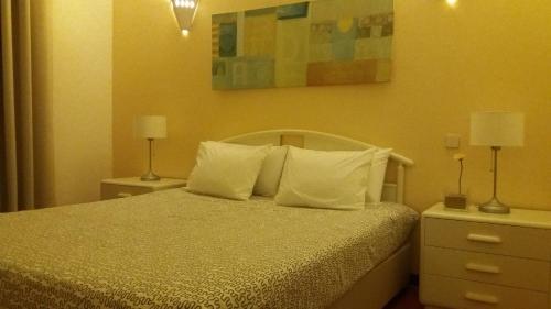 a hotel room with a bed and a lamp at Travelers by Rio NaturAL in Vila Nova de Milfontes