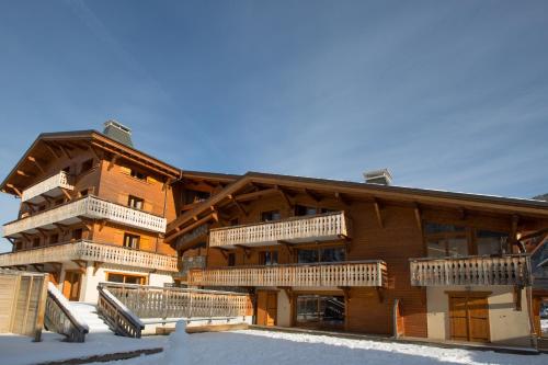 a large wooden building with balconies in the snow at Aiglon Morzine in Morzine