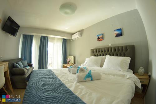 a bedroom with a large bed with two stuffed animals on it at The L Studio in Nea Peramos