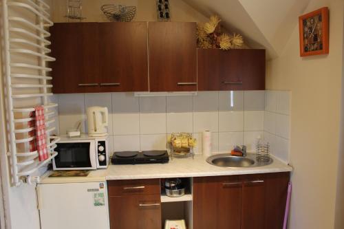 una pequeña cocina con fregadero y nevera. en Domek "Madzia", en Brenna