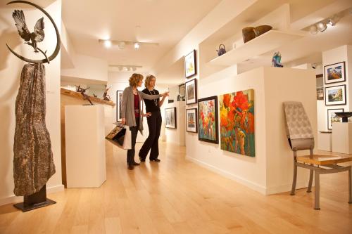 two women looking at art in a gallery at Fairmont Jasper Park Lodge in Jasper