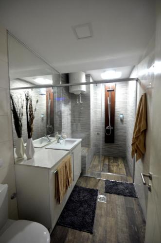 a bathroom with a sink and a toilet and a shower at Clean&Cozy Apartments Novi Beograd in Belgrade
