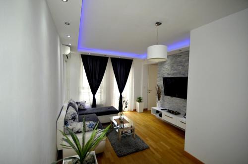 a living room with a couch and a tv at Clean&Cozy Apartments Novi Beograd in Belgrade