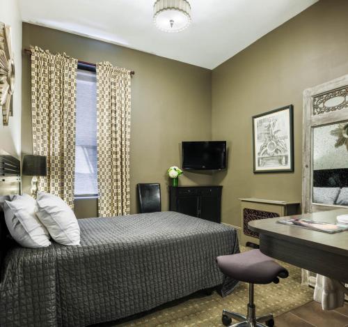 1 dormitorio con cama, escritorio y ventana en Seton Hotel, en Nueva York