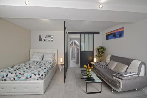 um quarto com uma cama e um sofá em Le Franche Comté Centre Ville Rive Droite em Laval