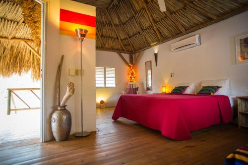 Habitación con cama con mesa roja en Mondi Lodge, en Dorp Sint Michiel