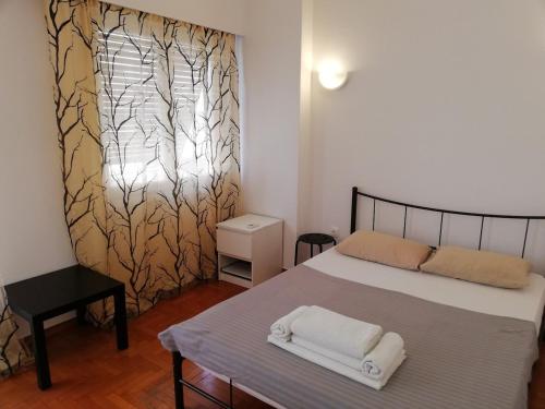 ein Schlafzimmer mit einem Bett mit zwei Handtüchern darauf in der Unterkunft Sfiggos 54 Guest House in Athen