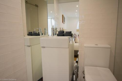 a bathroom with a toilet and a sink and a mirror at Lisbon Getaway Santo António Apartment in Lisbon