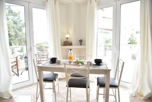 - une salle à manger avec une table, des chaises et des fenêtres dans l'établissement KyMa Studios and Suites, à Asprovalta