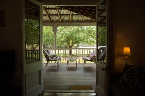 an open door to a porch with chairs and a table at The Carriages Boutique Hotel and Vineyard in Pokolbin