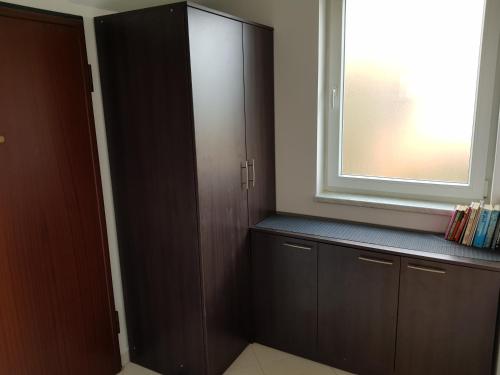 Cette chambre dispose d'une grande armoire en bois et d'une fenêtre. dans l'établissement Apartment Onbria Mar, à Medulin