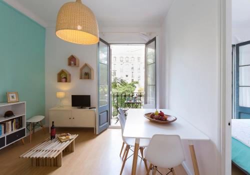 een woonkamer met een witte tafel en stoelen bij Cozy Flat With Unbeatable Views to Sagrada Familia in Barcelona