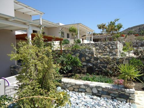 a garden with a stone wall and some plants at Mythos Suites Diskos in Léntas