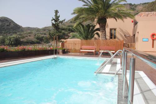 - une piscine dans une maison avec un palmier dans l'établissement Hotel Rural El Mondalón, à Las Palmas de Gran Canaria