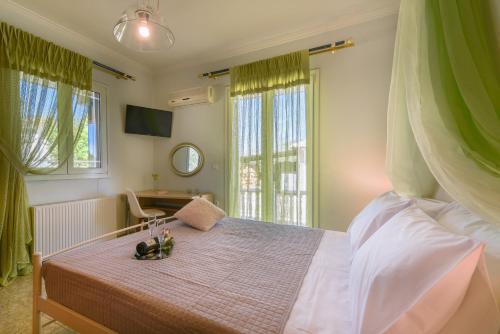 a bedroom with a bed and a desk and windows at Fontana Holiday Home in Mouzákion