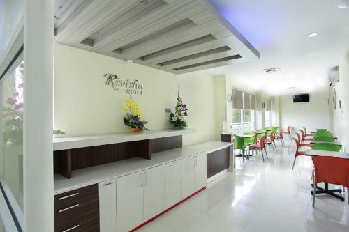 een eetkamer met tafels en stoelen en een bord aan de muur bij Rivisha Hotel in Yogyakarta