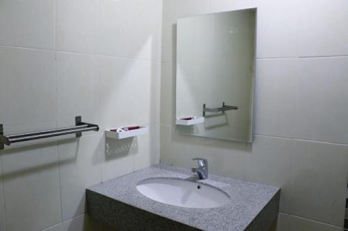 y baño con lavabo y espejo. en Diyar Villas Puncak Q4/11, en Puncak