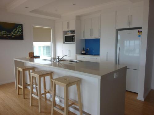 una cocina con una encimera grande con taburetes. en Lincoln View Holiday House, en North Shields