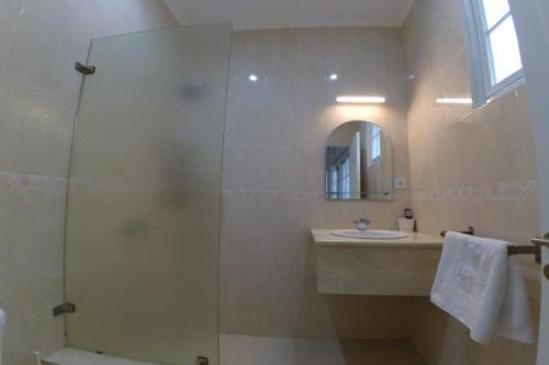 a bathroom with a shower and a sink and a mirror at Diyar Villas Puncak M6/50 in Puncak