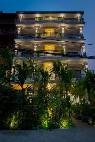 a large white building with lights on it at Bokre Angkor Hostel in Siem Reap