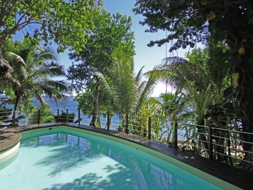 uma piscina com árvores e o oceano ao fundo em Paradise Cove Resort em Port Vila