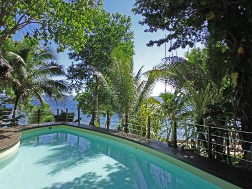 una piscina con árboles y el océano en el fondo en Paradise Cove Resort, en Port Vila