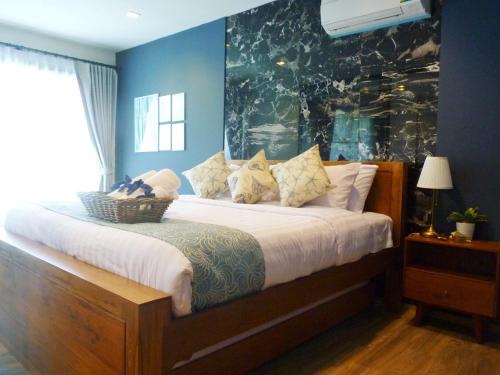 a bedroom with a large bed with blue walls at Rain Cha-am Huahin By Sake in Cha Am