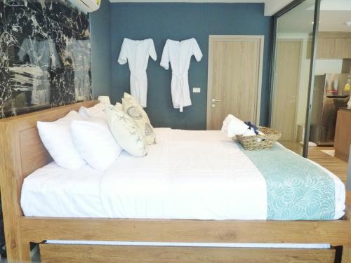 a bedroom with a bed with white sheets and white pillows at Rain Cha-am Huahin By Sake in Cha Am