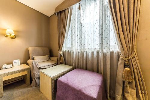 a room with a window with a chair and a table at Incheon Airport Hotel Seattle in Incheon