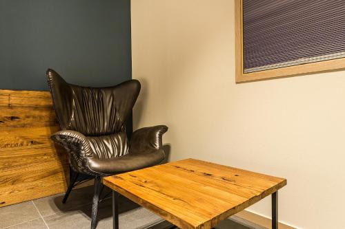 a leather chair sitting next to a wooden table at Incheon Airport Hotel Seattle in Incheon
