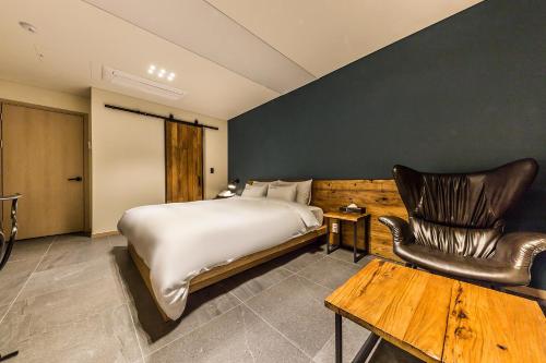 a bedroom with a bed and a table and chairs at Incheon Airport Hotel Seattle in Incheon