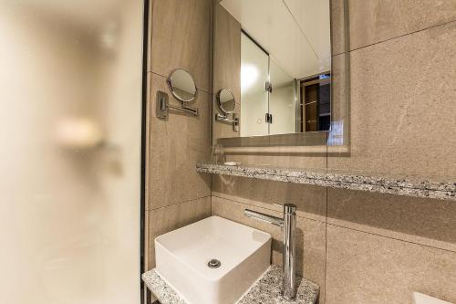 a bathroom with a white sink and a mirror at Incheon Airport Hotel Seattle in Incheon