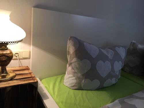a pillow sitting on a bed next to a lamp at Apartmentshaus Elbblick Zimmer "Bergblick" in Bad Schandau