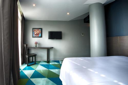 a bedroom with a bed and a table in a room at G1 Lodge in Baguio