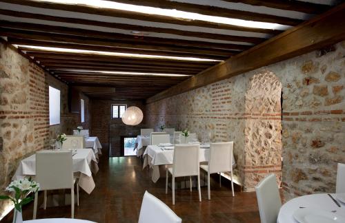 una sala da pranzo con tavoli bianchi e sedie bianche di El Pontifical a Los Santos de la Humosa