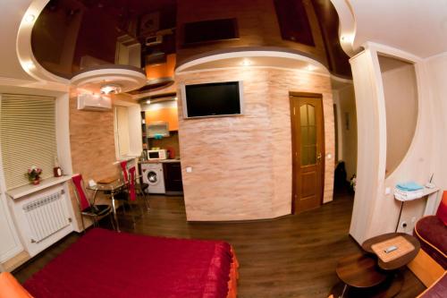 ein Wohnzimmer mit einem roten Sofa und einem TV in der Unterkunft затишна квартирка in Krementschuk